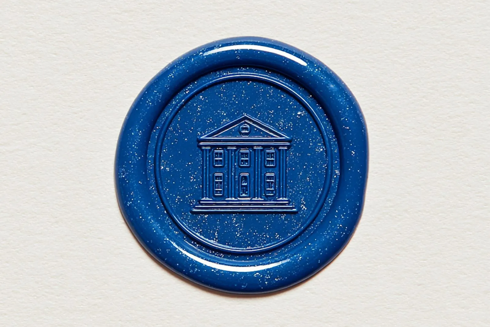 Sello de lacre azul con el grabado de un edificio institucional